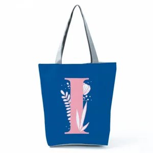 Blue tote bag detail showcasing pink floral letter print and durable silver shoulder straps.