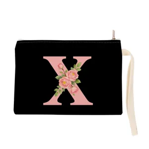 Black canvas cosmetic bag featuring a pink floral monogram letter X and handy wrist strap.