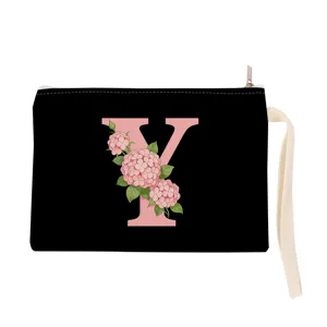 Black canvas cosmetic bag with pink floral letter Y print and convenient wrist strap.