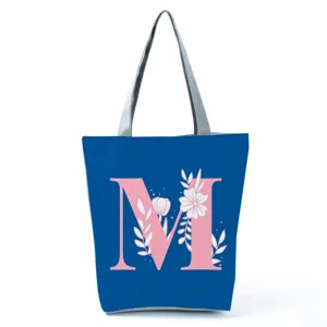 Blue tote bag with pink letter M and floral print, stylish and spacious shoulder handbag.