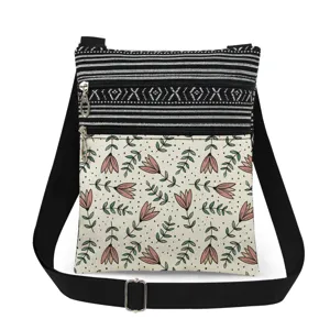 Close-up detail of the printed canvas crossbody bag featuring dual zippered pockets and pattern.
