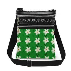 Details of the small green floral crossbody bag with double zippers and adjustable strap.