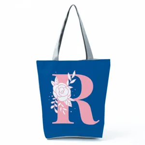 Detailed close-up view of the blue floral letter R canvas tote bag with shoulder straps.