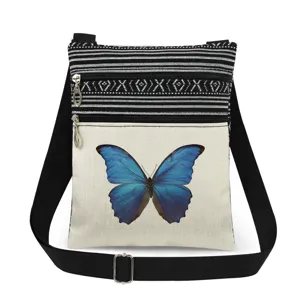 Elegante bolso cruzado de lona con estampado de mariposa azul y correa ajustable.
