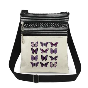 Detalles en primer plano del bolso bandolera de lona con estampado de mariposas moradas.