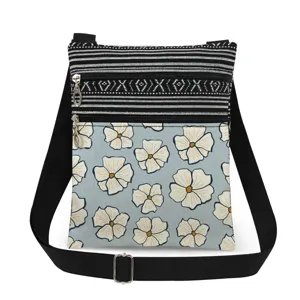 Small floral crossbody messenger bag with dual zippers and adjustable black fabric strap.