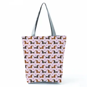 Primo piano dettaglio di borsa shopper spalla tela rosa stampa cani bassotti carini.