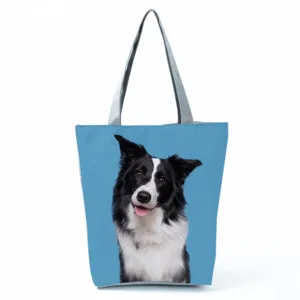 Detailed view of the blue canvas tote bag featuring a cute border collie dog print and sturdy handles.