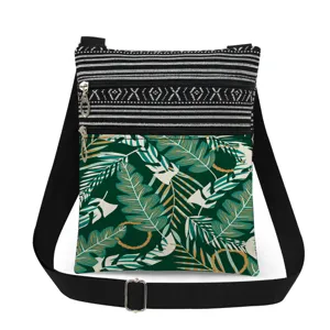 Crossbody bag with green tropical leaf print, double zippers and adjustable black strap.