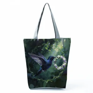 Detailweergave van de elegante totebag met kolibrie- en bloemenprint en stevige grijze handvatten.
