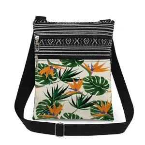Tropical print crossbody bag detail showcasing double zippers and adjustable black strap.