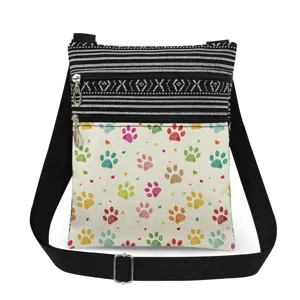Sac bandoulière en toile à rayures noires et blanches et motifs de pattes colorés réglable.