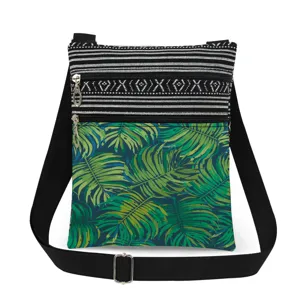 Tropical print crossbody bag with dual zippers, adjustable black strap, and stylish design.