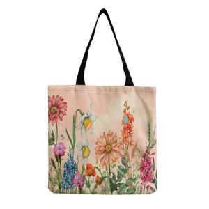 Vue détaillée du sac cabas en toile à fleurs aquarelle décontracté avec bandoulières noires.