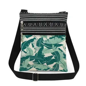 Stylish tropical leaf crossbody bag with double zippers, black white stripes and adjustable strap.