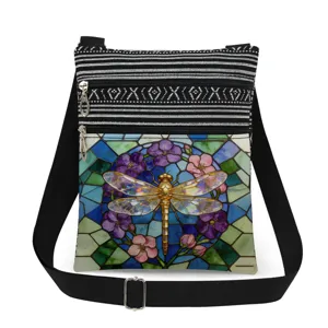 Close-up detail of the stained glass dragonfly print canvas crossbody bag strap and zipper.