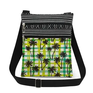 Detail view of tropical palm tree print and dual zipper pockets on casual canvas crossbody bag.