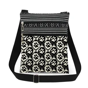 Vue détaillée du sac bandoulière noir et blanc avec motif patte de chat et sangle.