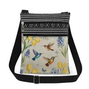 Detailed view of the lightweight hummingbird and floral print canvas crossbody bag.