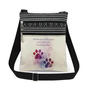 Vue détaillée du sac bandoulière en toile avec empreinte de patte et sangle réglable.