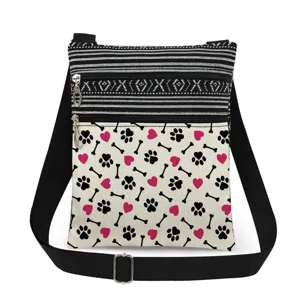 Gros plan du sac bandoulière avec motif de pattes de chat, doubles zips et bandoulière noire.