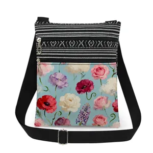 Floral print canvas crossbody bag with black white striped upper zipper pocket and adjustable strap.