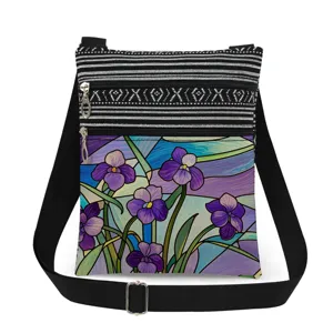 Details of crossbody bag with stained glass purple floral print, adjustable strap and double zippers.