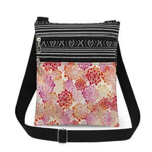Details of the small floral print crossbody bag with dual zippers and adjustable strap.