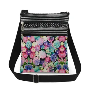 Detailed view of small crossbody bag with colorful floral print and black striped top.