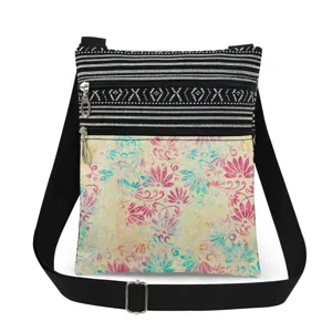 Detailed view of the small crossbody bag with colorful floral print, double zippers and strap.