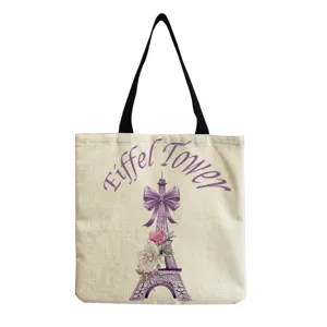 Detailed shot of the Eiffel Tower print canvas tote bag, featuring floral bow and sturdy strap.