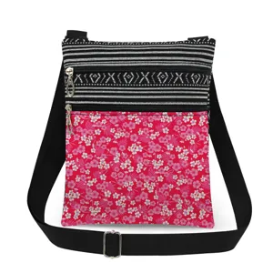 Small floral crossbody bag with dual zippers, black and white striped design and adjustable strap.