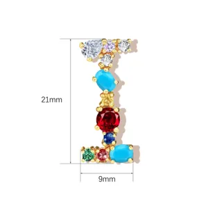 Close-up detail of a colorful gemstone letter pendant, cubic zirconia crystal and copper.