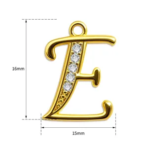 Fein detaillierter Buchstabe E Anhänger in Gold mit funkelnden Zirkonia Steinen.