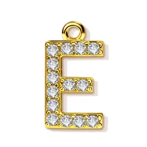 Gold letter E pendant detail, close-up view of sparkling rhinestone pavé setting on metal.