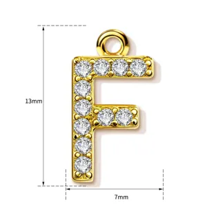 Detailed view of gold letter F pendant, paved with sparkling cubic zirconia stones.