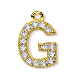 Gold paved letter G pendant detail close-up, shiny cubic zirconia alphabet jewelry accessory.