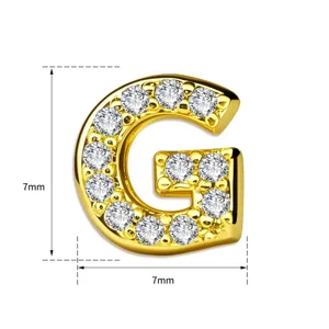 Detailopname van een vergulde koperen letter G hanger bezet met schitterende zirkonia.