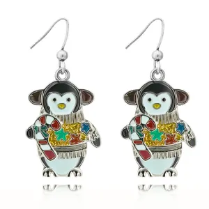 Detail shot of Christmas penguin enamel dangle earrings with colorful crystal stars.