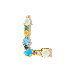 Letter L pendant detail showing multi-color cubic zirconia stones inlaid on gold plated copper.