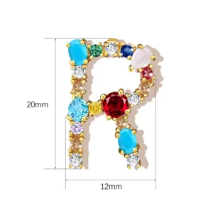 Detailed view of colorful cubic zirconia letter R pendant, copper jewelry accessory.
