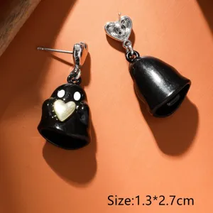Dettaglio di orecchini fantasma nero carino, ciondolo in lega con cuore dorato chic.