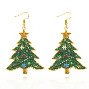 Close-up detail of green glitter Christmas tree hook earrings with gold trim and cute charms.