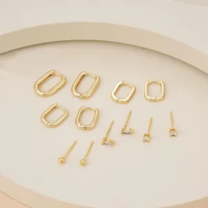 Detailed view of fashionable gold hoop and stud earrings set, minimalist style accessory.