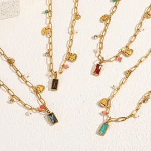 Detail view of stylish gold chain necklaces with colorful rectangular birthstone and heart charms.