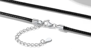 Dettaglio chiusura collana in corda di pelle nera intrecciata, moschettone in metallo.