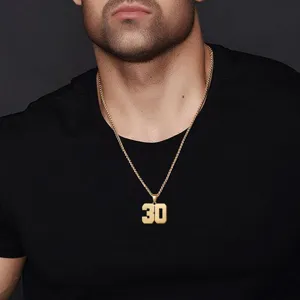Primo piano dettaglio della splendida collana con ciondolo numero 30 in oro su camicia.