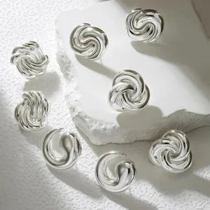 Stunning silver abstract twist earrings detail view, modern geometric fashion jewelry accessory design.