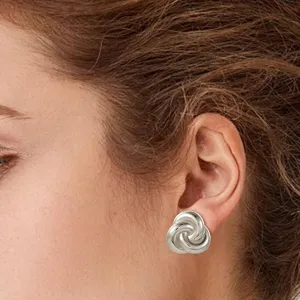 Silver intertwined knot earrings, elegant small minimalist metal stud jewelry for women.