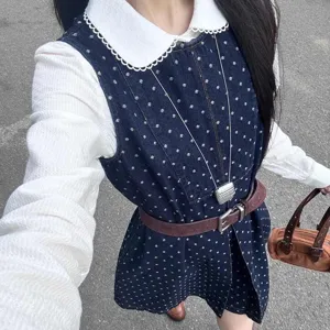Primo piano dettagliato di una elegante collana lunga argentata indossata con un outfit chic.